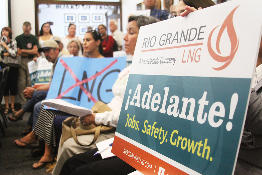 Both supporters and opponents of LNG carried signs at Tuesday's school board meeting. (Dina Arévalo | Staff photographer)